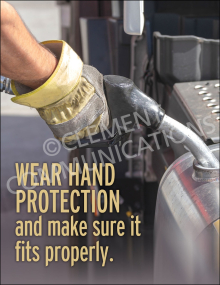 A close-up of a worker's hand in a heavy-duty protective safety glove holding a fuel nozzle while refueling a vehicle or machine tank.