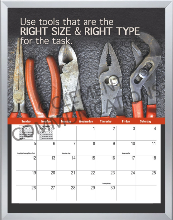 Employee viewing a large, wall-mounted safety calendar poster that tracks site inspections, training dates, and daily safety goals.