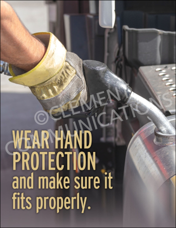 A close-up of a worker's hand in a heavy-duty protective safety glove holding a fuel nozzle while refueling a vehicle or machine tank.